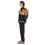 The MCM Medium Aren Backpack in Visetos Cognac embodies contemporary elegance with its sleek rectangular silhouette, designed to accommodate essential tech gadgets like laptops, tablets, and documents. Crafted for the modern individual, this backpack seamlessly merges functionality with timeless style, boasting a soft microfiber suede interior that provides a luxurious backdrop for your belongings. Measuring approximately 5.1 x 12.2 x 16.5 inches, this backpack offers ample storage space while maintaining a streamlined profile. Its adjustable logo-woven shoulder straps ensure a comfortable fit, allowing you to carry your essentials with ease throughout the day. Additionally, a leather top handle provides versatility in carrying options, whether you prefer to sling it over your shoulders or hold it by hand. At the forefront of the design is MCM's commitment to quality craftsmanship, evident in the meticulous construction from signature Visetos monogram canvas and premium nappa leather. The Visetos monogram, an iconic symbol of the brand, adorns the exterior, exuding sophistication and style. Nappa leather trim accents add a touch of refinement, enhancing the backpack's overall aesthetic appeal. Practical features such as a front zip pocket and interior slip pocket offer convenient storage for smaller items, keeping them easily accessible when you're on the go. The two-way zip closure ensures secure closure, safeguarding your belongings while providing effortless access. Comfort is prioritized with a padded back panel, providing cushioning and support for extended wear. Matte black metal hardware adds a modern edge to the design, complementing the rich tones of the Visetos monogram and nappa leather trim. Designed and crafted in South Korea, this backpack exemplifies MCM's commitment to quality and innovation. Its fusion of modern utility and heritage craftsmanship makes it an essential accessory for the contemporary individual seeking both style and functionality in their everyday carry. Whether for work, travel, or leisure, the MCM Medium Aren Backpack is a versatile companion that effortlessly elevates any ensemble.