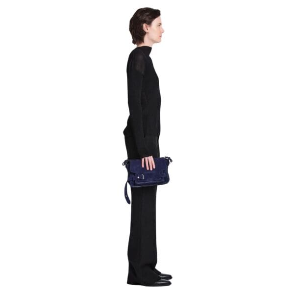Indulge in understated elegance with the Beacon Saddle Bag in Suede, a captivating creation that pays homage to the rugged charm of traditional workwear satchels. Crafted from sumptuously supple suede in a deep, alluring dark blue hue, this accessory embodies sophistication and refinement while embracing its utilitarian inspiration. The Beacon Saddle Bag in Suede is a testament to the brand's dedication to superior craftsmanship and meticulous attention to detail. The supple suede material lends a luxurious touch to the design, inviting touch and admiration with its velvety texture and rich color. At the forefront of the design are the signature belted straps adorned with a distinguished D-ring buckle, securing the fold-over flap with both practicality and style. Inspired by the functionality of workwear satchels, these straps add a touch of rugged elegance to the bag while ensuring the safety of your belongings. Versatility is key with the adjustable shoulder strap, allowing you to effortlessly transition from day to night with ease and comfort. Whether worn crossbody for hands-free convenience or elegantly draped over the shoulder, this thoughtful addition ensures that the bag complements your every movement with grace and style. Practicality meets sophistication with the inclusion of a zip top fastening, providing secure closure for your essentials, while a zip back pocket offers convenient access to items on the go. Inside, an internal zip pocket further enhances organization, keeping your belongings neatly stowed within the spacious interior. Elevating the bag's aesthetic appeal are silver-tone metal hardware accents, adding a touch of modernity and refinement to its timeless design. From the precise stitching to the polished hardware, each detail is meticulously executed, reflecting the brand's dedication to impeccable craftsmanship and quality. In essence, the Beacon Saddle Bag in Suede epitomizes the perfect blend of classic elegance and contemporary sophistication. With its exquisite craftsmanship, thoughtful design, and enduring appeal, it stands as a testament to the brand's commitment to timeless style and impeccable quality, inviting you to elevate your ensemble with effortless sophistication and grace.