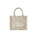 The Versace Barocco Athena Extra Small Tote Bag is an exquisite fusion of opulence, sophistication, and timeless elegance. Crafted with meticulous attention to detail, this iconic piece encapsulates the essence of the Versace brand, showcasing its signature Barocco motif and distinctive design elements. At first glance, the bag exudes a sense of luxury, boasting a striking combination of rich textures and vibrant hues. The Barocco motif, synonymous with Versace's heritage, adorns the exterior of the bag, intricately woven into the fabric with precision and finesse. Its bold and intricate patterns pay homage to classical Greek and Roman art, adding a touch of regal grandeur to the design. Constructed from premium materials of the highest quality, the tote bag is both durable and luxurious. The supple leather exterior is soft to the touch, while the gleaming gold-tone hardware adds a touch of glamour and refinement. The structured silhouette maintains its shape effortlessly, exuding an air of sophistication and poise. Practical yet stylish, the Extra Small Tote Bag is designed to cater to the modern woman's lifestyle. Despite its compact size, the interior offers ample space to accommodate essentials such as keys, phone, wallet, and makeup, making it ideal for both day-to-day use and special occasions. The interior is lined with sumptuous satin fabric, providing a luxurious backdrop for your belongings. Versatility is another hallmark of this timeless accessory. Whether carried by the top handles for a polished look or slung over the shoulder using the detachable strap for added convenience, the tote bag effortlessly transitions from day to night, complementing any ensemble with effortless sophistication. In conclusion, the Versace Barocco Athena Extra Small Tote Bag is a true masterpiece that embodies the epitome of luxury and style. With its exquisite craftsmanship, iconic design, and practical functionality, it is more than just a fashion accessory—it is a symbol of prestige, refinement, and enduring elegance.
