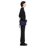 Indulge in understated elegance with the Beacon Saddle Bag in Suede, a captivating creation that pays homage to the rugged charm of traditional workwear satchels. Crafted from sumptuously supple suede in a deep, alluring dark blue hue, this accessory embodies sophistication and refinement while embracing its utilitarian inspiration. The Beacon Saddle Bag in Suede is a testament to the brand's dedication to superior craftsmanship and meticulous attention to detail. The supple suede material lends a luxurious touch to the design, inviting touch and admiration with its velvety texture and rich color. At the forefront of the design are the signature belted straps adorned with a distinguished D-ring buckle, securing the fold-over flap with both practicality and style. Inspired by the functionality of workwear satchels, these straps add a touch of rugged elegance to the bag while ensuring the safety of your belongings. Versatility is key with the adjustable shoulder strap, allowing you to effortlessly transition from day to night with ease and comfort. Whether worn crossbody for hands-free convenience or elegantly draped over the shoulder, this thoughtful addition ensures that the bag complements your every movement with grace and style. Practicality meets sophistication with the inclusion of a zip top fastening, providing secure closure for your essentials, while a zip back pocket offers convenient access to items on the go. Inside, an internal zip pocket further enhances organization, keeping your belongings neatly stowed within the spacious interior. Elevating the bag's aesthetic appeal are silver-tone metal hardware accents, adding a touch of modernity and refinement to its timeless design. From the precise stitching to the polished hardware, each detail is meticulously executed, reflecting the brand's dedication to impeccable craftsmanship and quality. In essence, the Beacon Saddle Bag in Suede epitomizes the perfect blend of classic elegance and contemporary sophistication. With its exquisite craftsmanship, thoughtful design, and enduring appeal, it stands as a testament to the brand's commitment to timeless style and impeccable quality, inviting you to elevate your ensemble with effortless sophistication and grace.